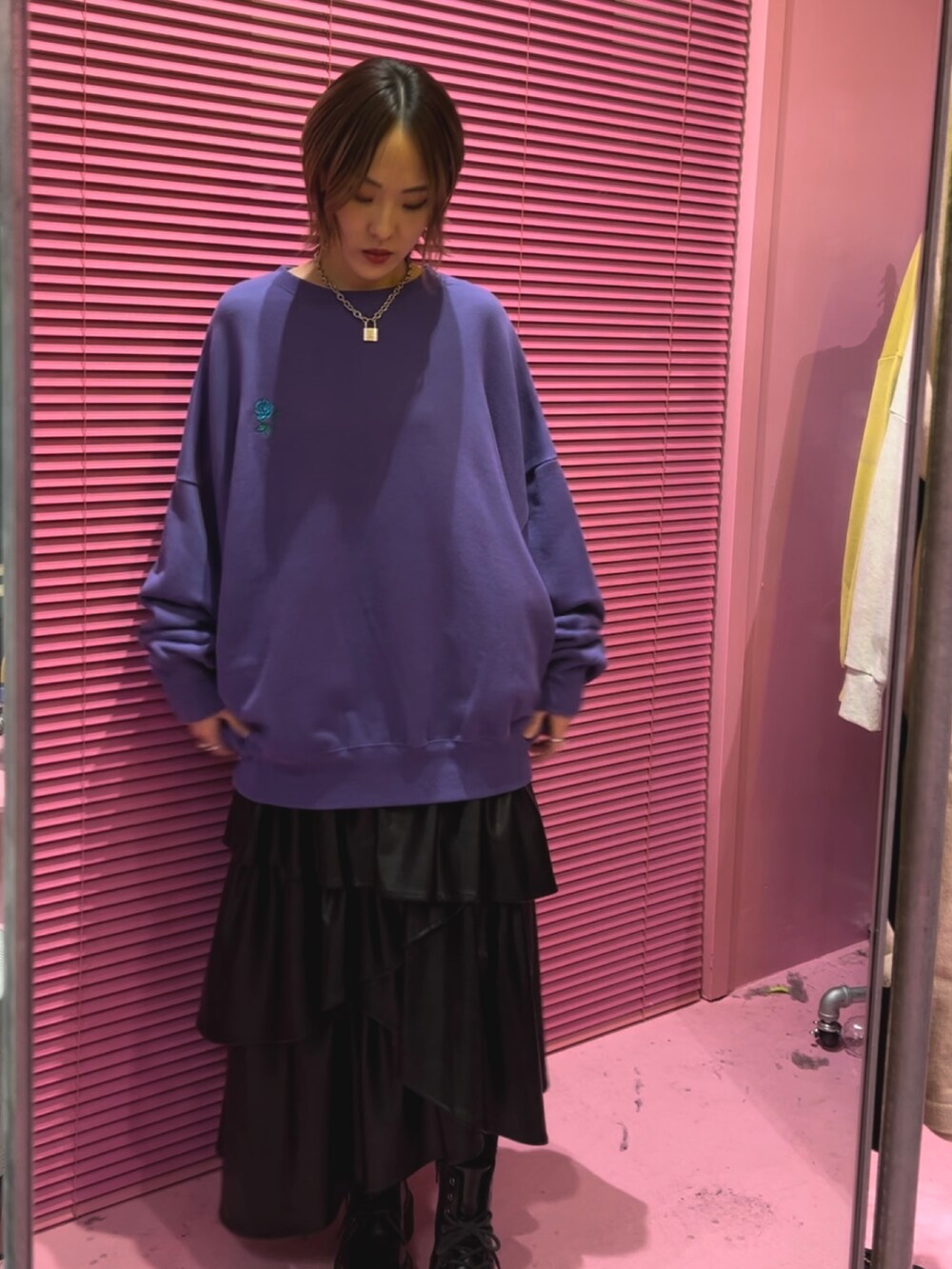 パープル系のTシャツ/カットソー、ブラック系のスカート、ブラック系のブーツを着用したレディースの秋コーディネートの2枚目の写真