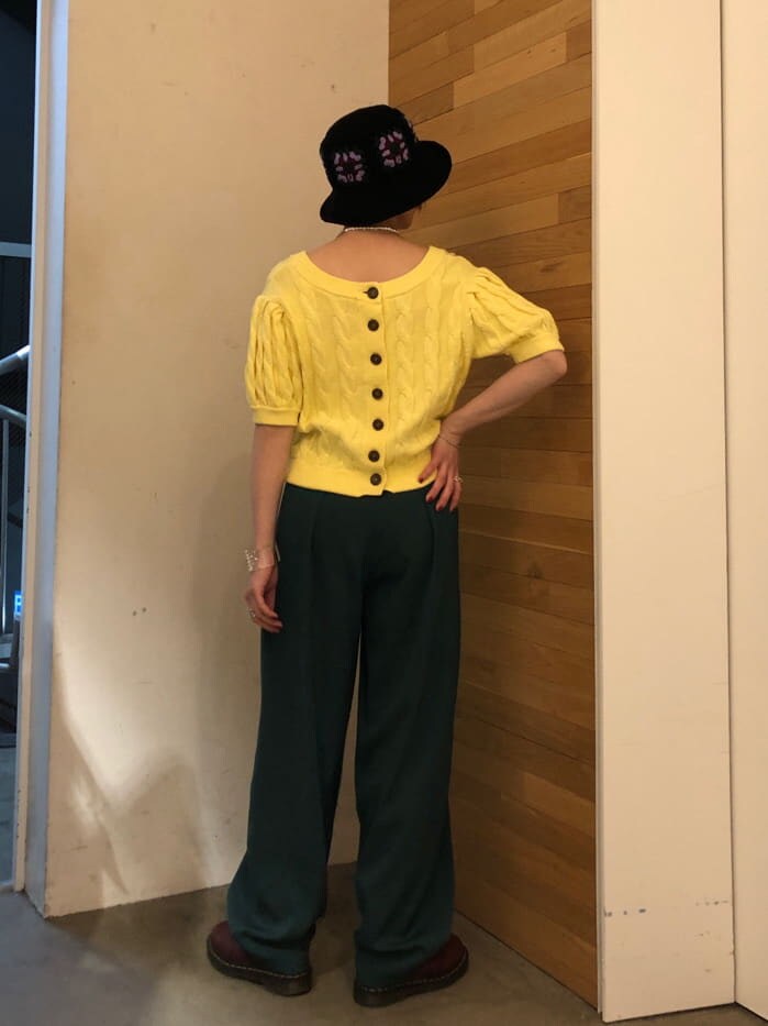 グリーン系のスラックス、イエロー系のニット/セーター、シルバー系のネックレスを着用したレディースの冬コーディネートの2枚目の写真