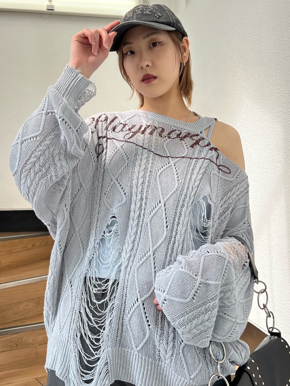 ブラック系のパンプス、ブラック系のカーゴパンツ、ブルー系のキャミソールを着用したレディースの春コーディネートの7枚目の写真