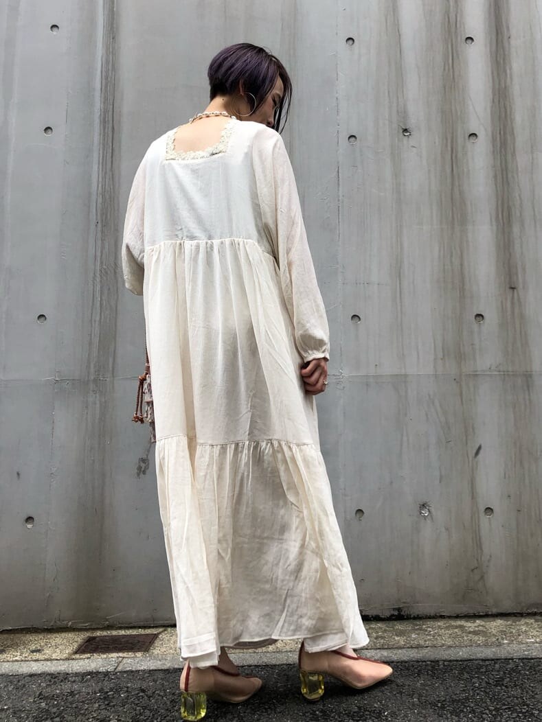 ホワイト系のワンピース、ホワイト系のパンプス、オレンジ系のハンドバッグを着用したレディースの夏コーディネートの4枚目の写真