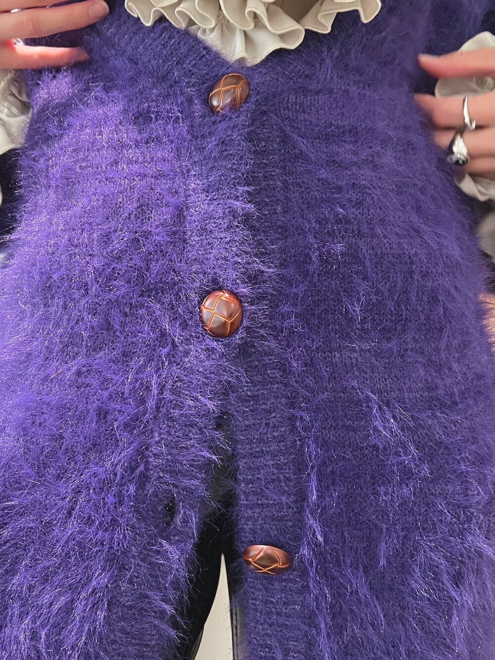 ホワイト系のシャツ/ブラウス、パープル系のカーディガン/ボレロ、ブラック系のデニムパンツを着用したレディースの冬コーディネートの8枚目の写真