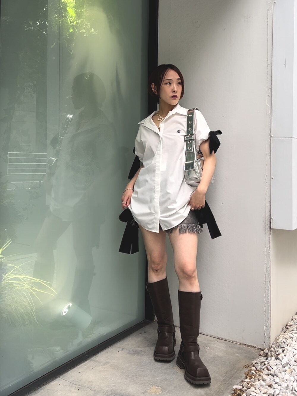 ホワイト系のシャツ/ブラウス、シルバー系のハンドバッグ、ブラック系のデニムパンツを着用したレディースの夏コーディネートの2枚目の写真