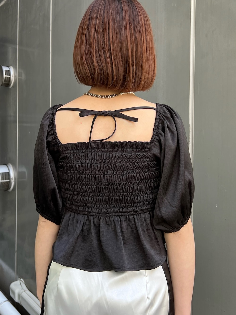 ホワイト系のスカジャン、ホワイト系のスカート、ブラック系のシャツ/ブラウスを着用したレディースの冬コーディネートの9枚目の写真