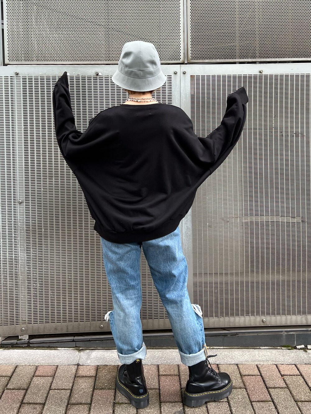 ブラック系のTシャツ/カットソー、ブルー系のデニムパンツ、ブラック系のブーツを着用したレディースの秋コーディネートの3枚目の写真