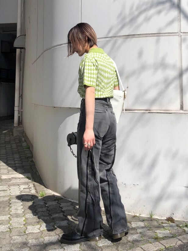 グリーン系のニット/セーター、ブラック系のデニムパンツ、ホワイト系のハンドバッグを着用したレディースの夏コーディネートの10枚目の写真
