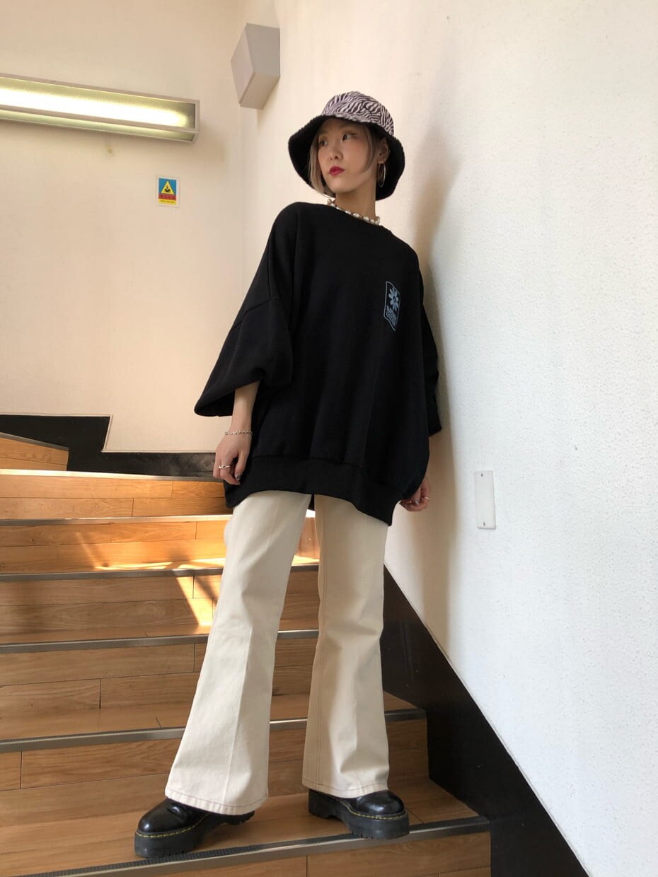 ホワイト系のデニムパンツ、ブラック系のスウェット、ブラック系のハットを着用したレディースの秋コーディネートの5枚目の写真