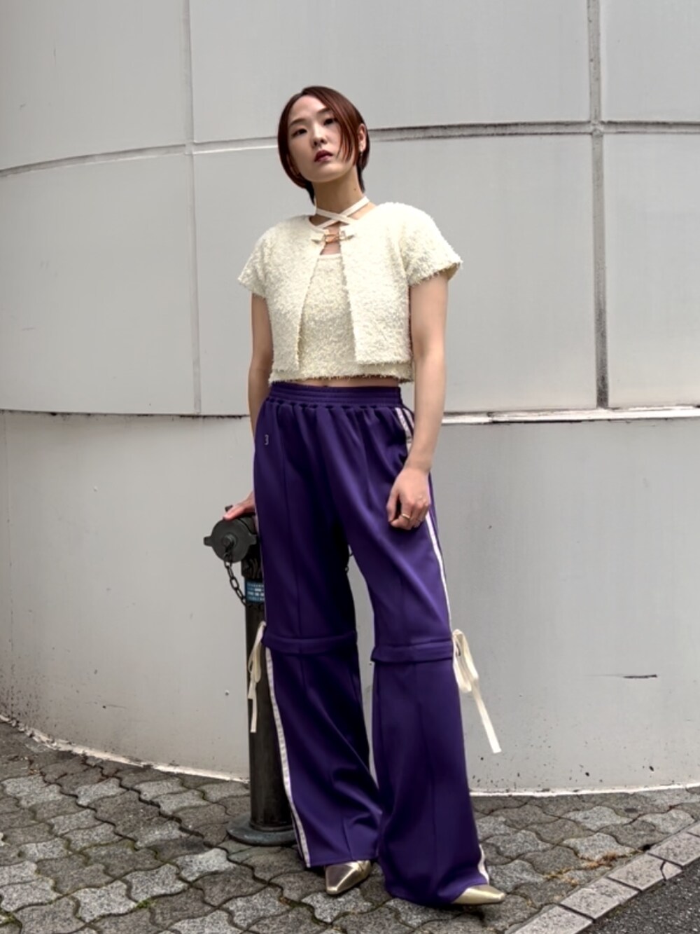 ホワイト系のアンサンブル、パープル系のその他パンツ、ゴールド系のパンプスを着用したレディースの夏コーディネートの2枚目の写真