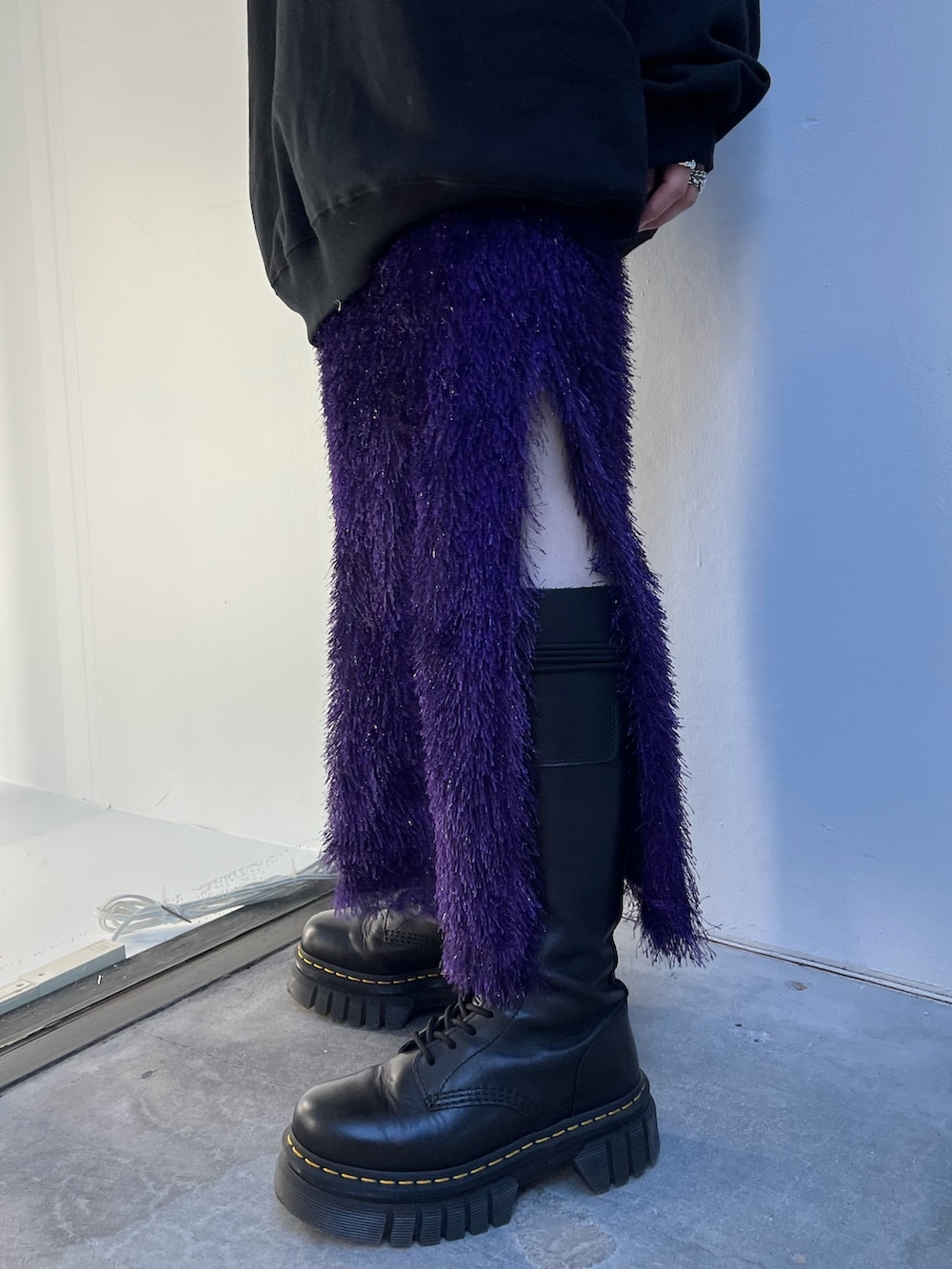 ブラック系のムートンコート、パープル系のスカート、ブラック系のスウェットを着用したレディースの夏コーディネートの10枚目の写真