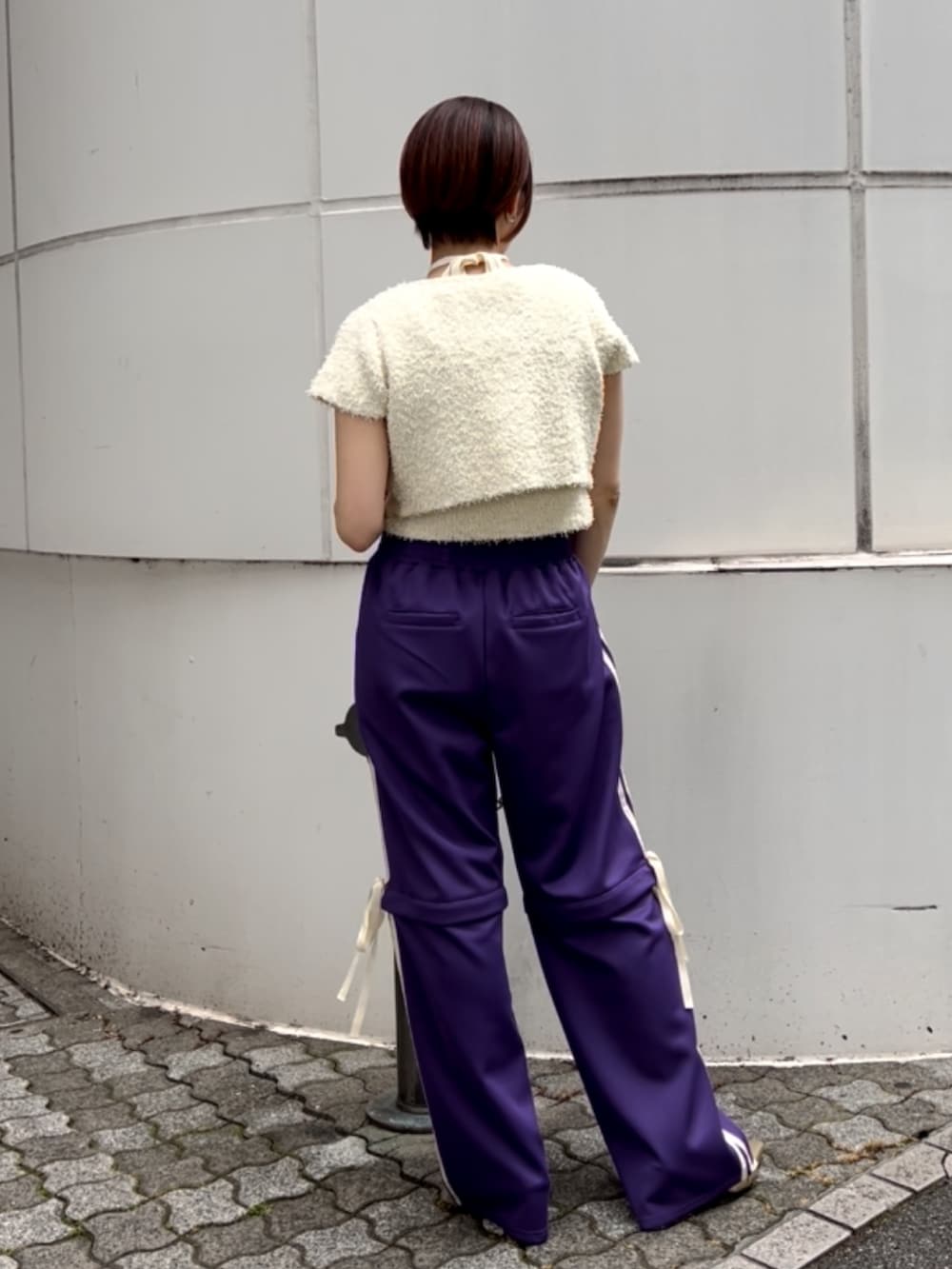 ホワイト系のアンサンブル、パープル系のその他パンツ、ゴールド系のパンプスを着用したレディースの夏コーディネートの5枚目の写真