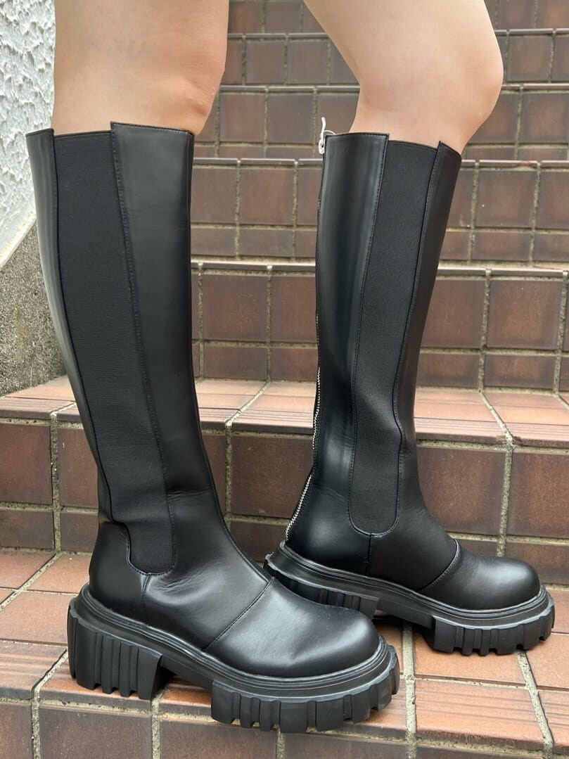 ブラック系のその他パンツ、ブラック系のブーツ、ホワイト系のTシャツ/カットソーを着用したレディースの夏コーディネートの10枚目の写真