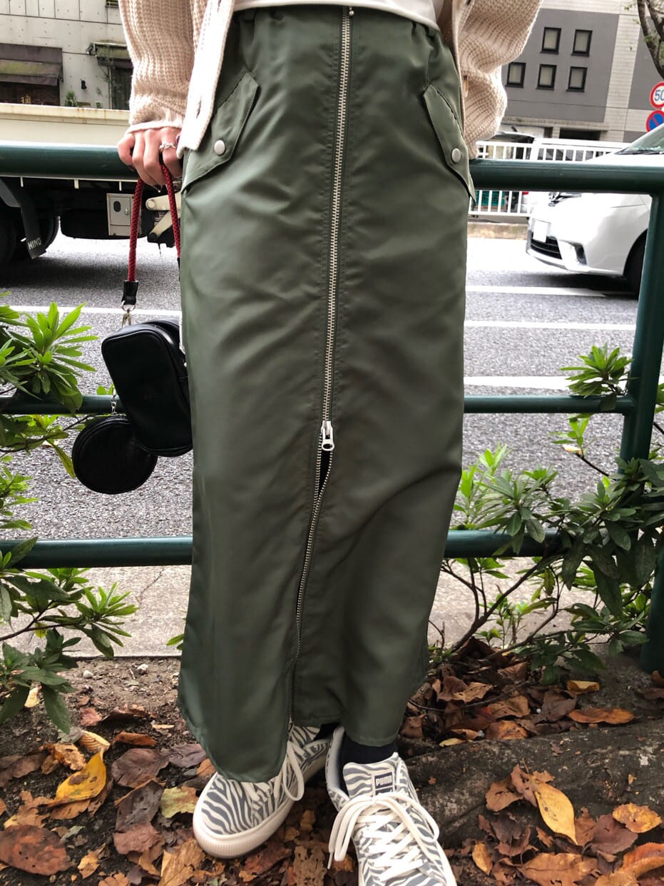 ブラック系のショルダーバッグ、ベージュ系のワンピース、ホワイト系のカーディガン/ボレロを着用したレディースの秋コーディネートの6枚目の写真