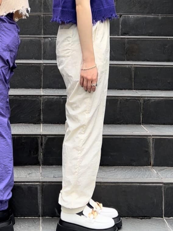 パープル系のベスト、ホワイト系のその他シューズ、ホワイト系のその他パンツを着用したレディースの秋コーディネートの5枚目の写真