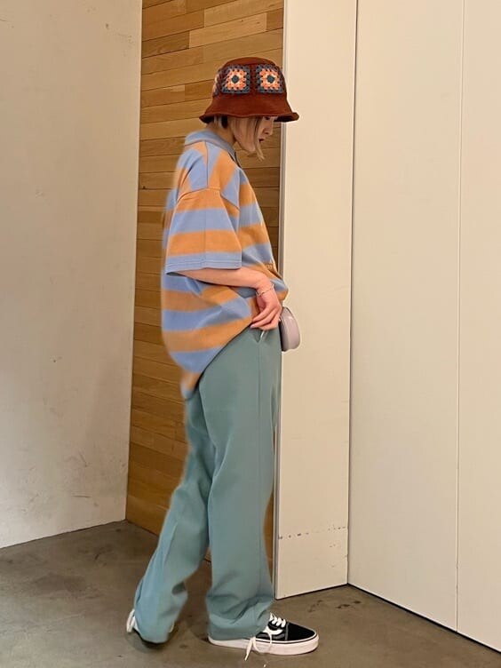 ブルー系のスラックス、グリーン系のハンドバッグ、ブルー系のTシャツ/カットソーを着用したレディースの夏コーディネートの4枚目の写真