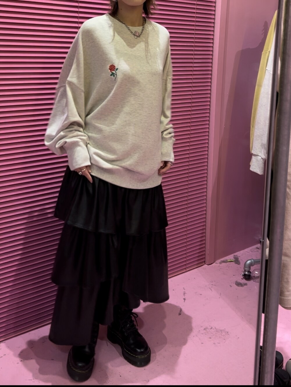 グレー系のTシャツ/カットソー、ブラック系のスカート、ブラック系のブーツを着用したレディースの秋コーディネートの3枚目の写真