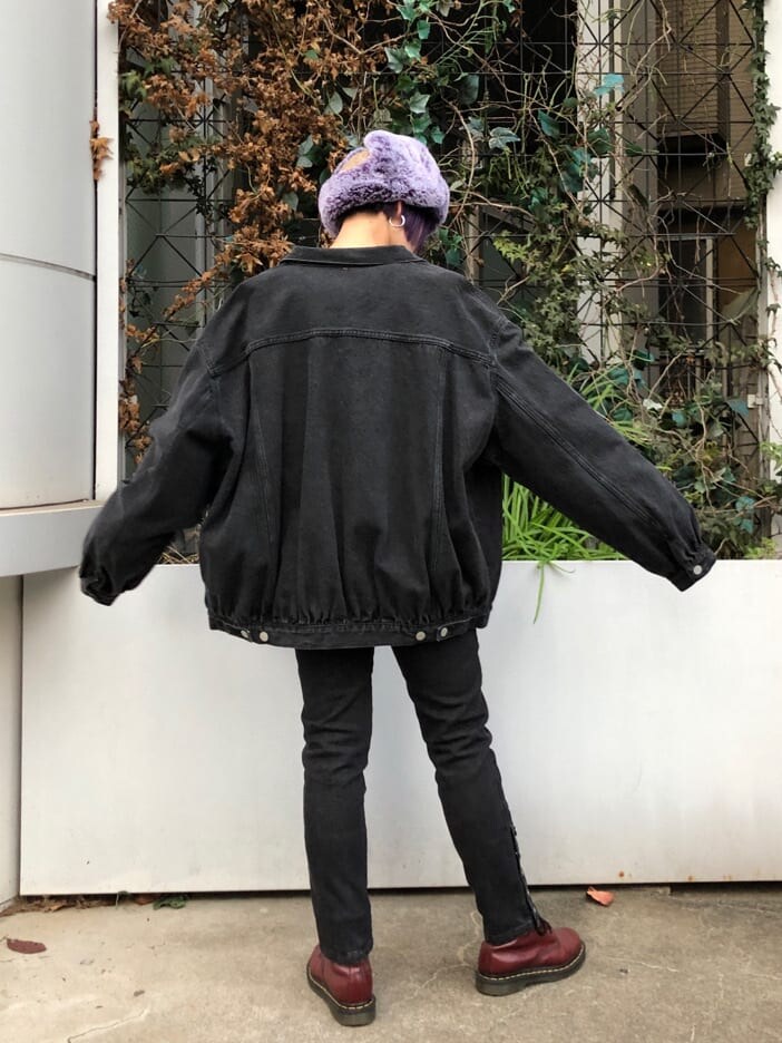 ブラック系のデニムパンツ、ブラック系のデニムジャケット、パープル系のカーディガン/ボレロを着用したレディースの冬コーディネートの4枚目の写真