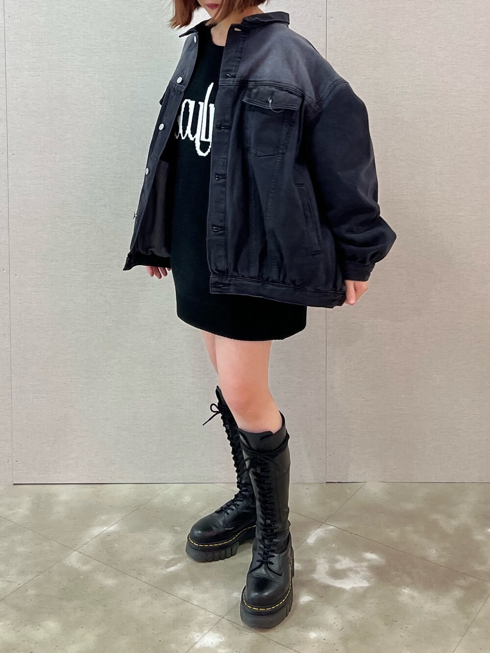 ホワイト系のニット/セーター、ブラック系のデニムジャケット、ブラック系のブーツを着用したレディースの春コーディネートの3枚目の写真