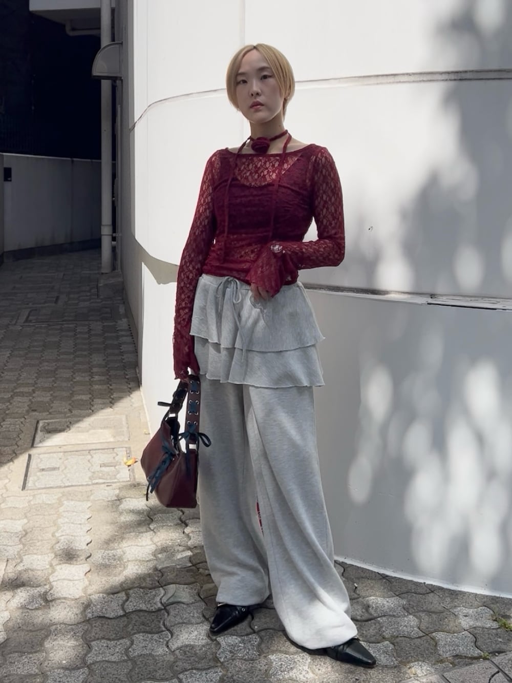 レッド系のTシャツ/カットソー、グレー系のスウェットパンツ、レッド系のハンドバッグを着用したレディースの夏コーディネートの2枚目の写真