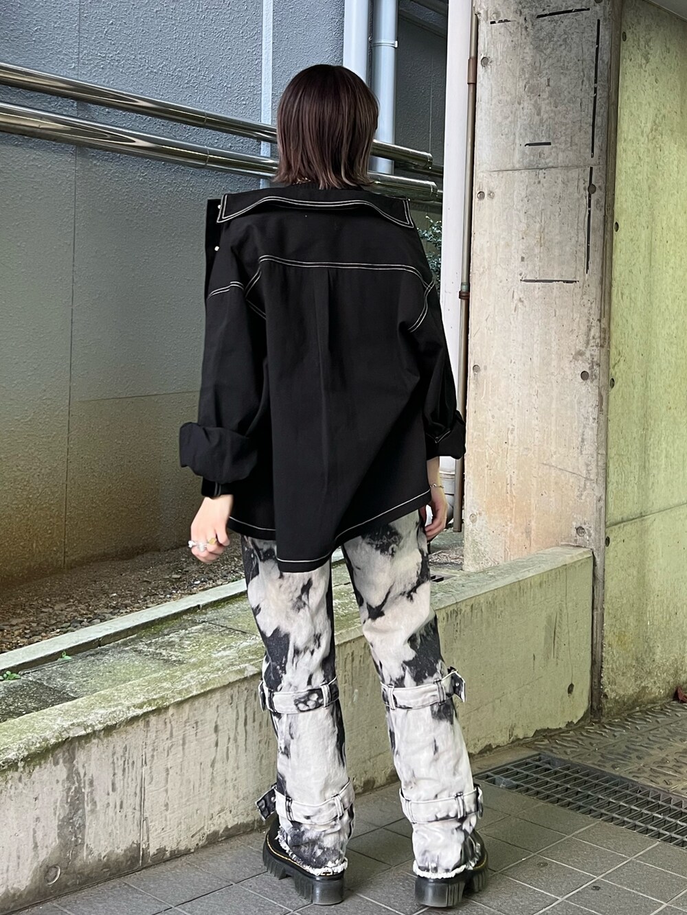 ブラック系のミリタリージャケット、ブラック系のベスト、ブラック系のデニムパンツを着用したレディースの冬コーディネートの3枚目の写真