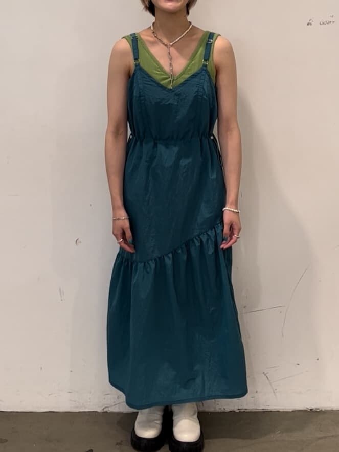 ホワイト系のブーツ、ブルー系のジャンパースカート、グリーン系のキャミソールを着用したレディースの秋コーディネートの4枚目の写真