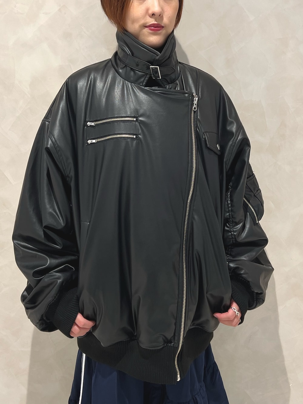 ブラック系のブルゾン、ブルー系のスカート、ブラック系のブーツを着用したレディースの秋コーディネートの7枚目の写真