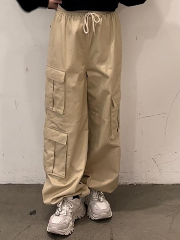 パープル系のカーディガン/ボレロ、ホワイト系のカーゴパンツ、ブラック系のスウェットを着用したレディースの秋コーディネートの8枚目の写真