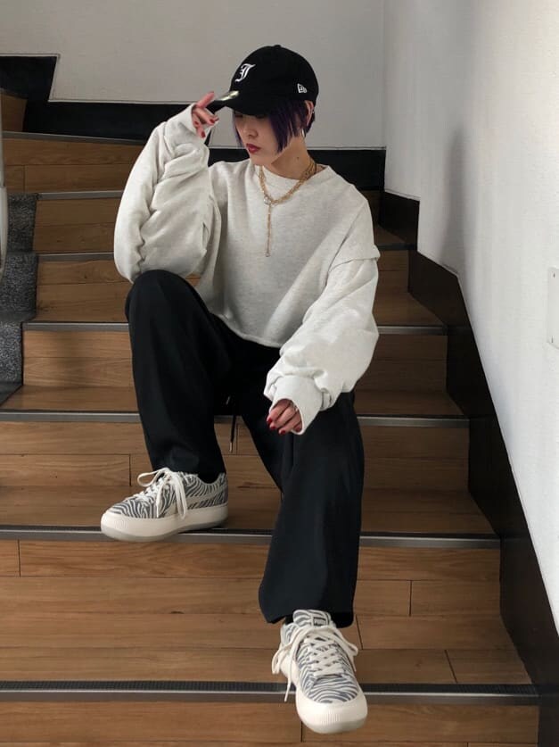 ブラック系のスラックス、グレー系のTシャツ/カットソー、ホワイト系のスニーカーを着用したレディースの冬コーディネートの4枚目の写真