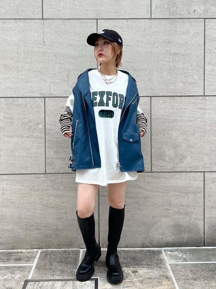 ブラック系のデニムパンツ、ホワイト系のTシャツ/カットソー、ブラック系のブーツを着用したレディースの秋コーディネートの2枚目の写真