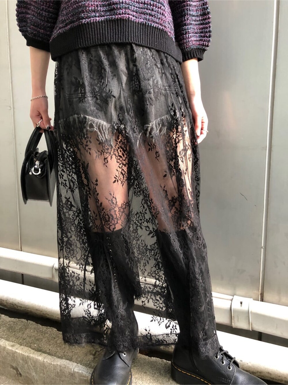 ブラック系のブーツ、ブラック系のデニムパンツ、ブラック系のショルダーバッグを着用したレディースの春コーディネートの8枚目の写真