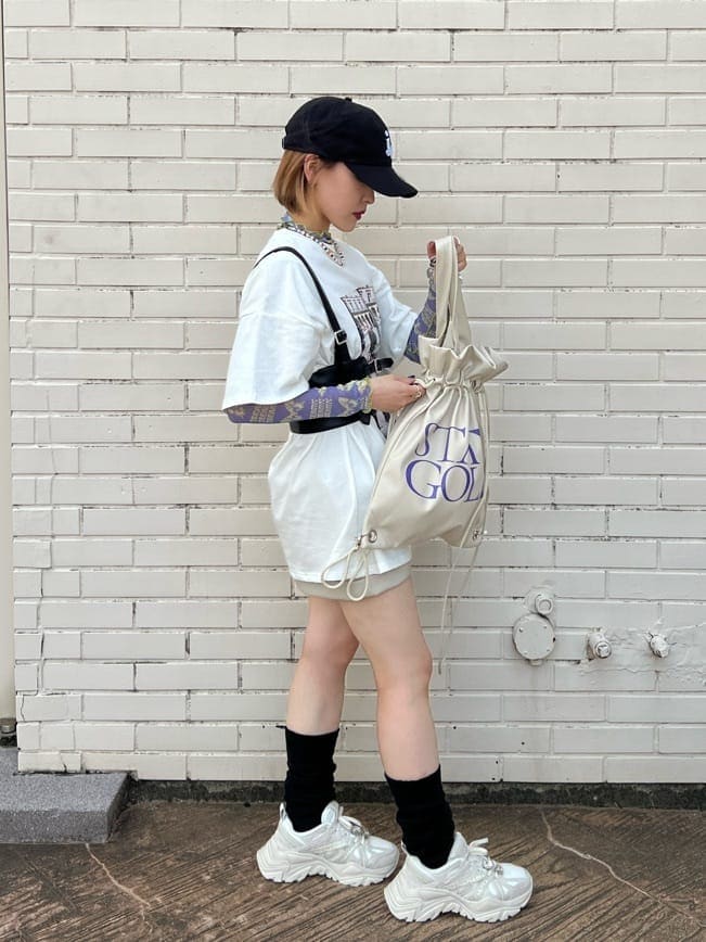 ホワイト系のスニーカー、ホワイト系のバックパック/リュック、ホワイト系のTシャツ/カットソーを着用したレディースの秋コーディネートの5枚目の写真