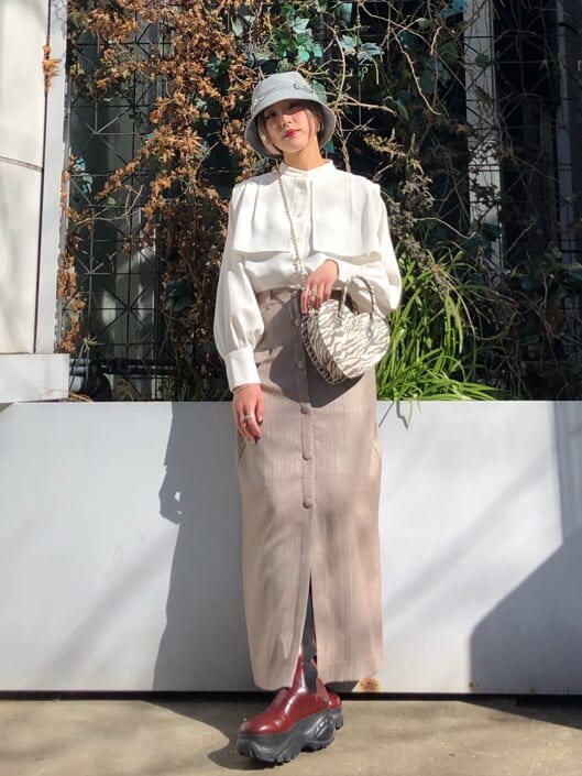 ホワイト系のシャツ/ブラウス、ベージュ系のスカート、その他のショルダーバッグを着用したレディースの春コーディネートの2枚目の写真