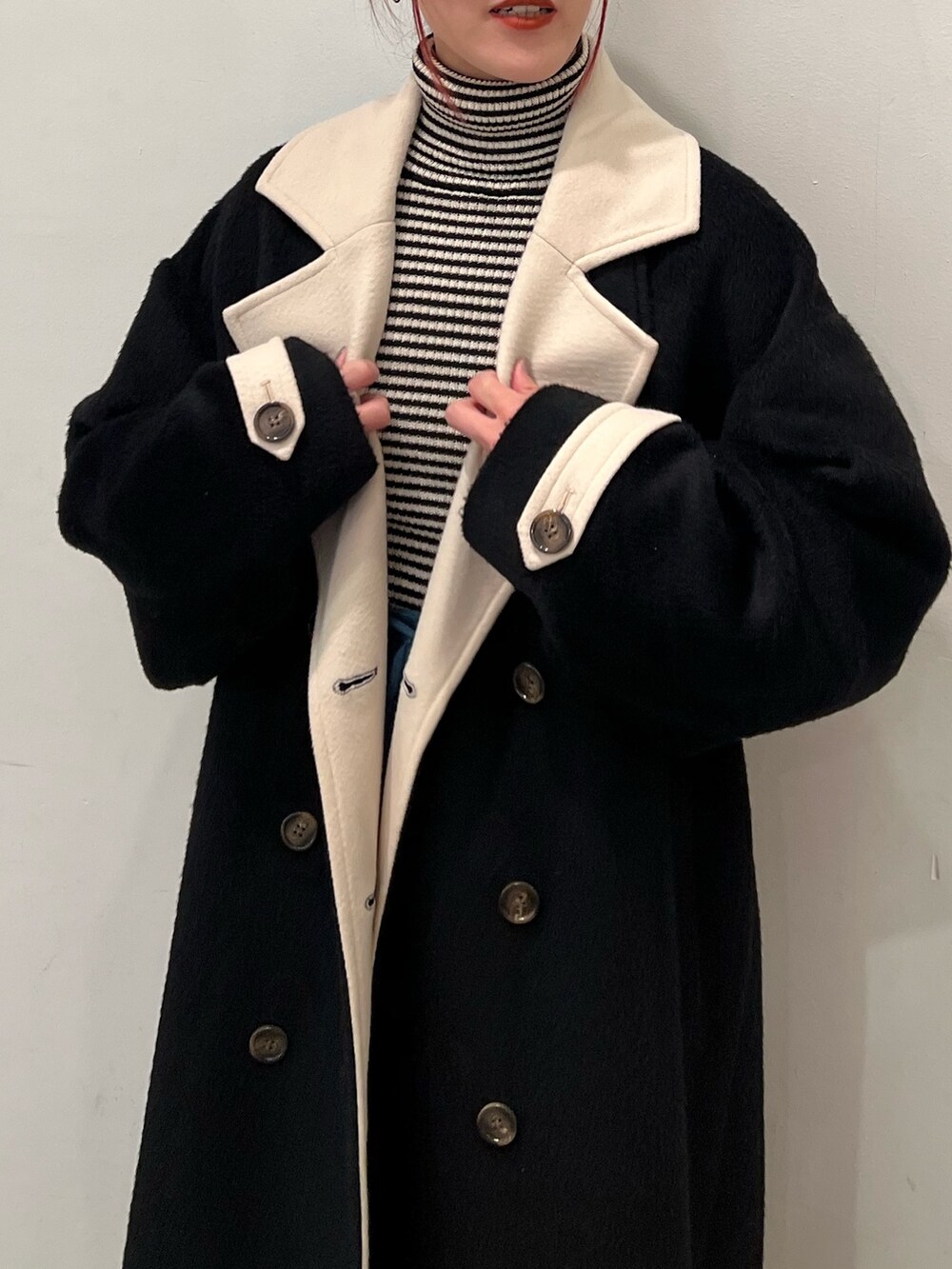 その他のニット/セーター、ブルー系のスカート、ブラック系のチェスターコートを着用したレディースの秋コーディネートの8枚目の写真