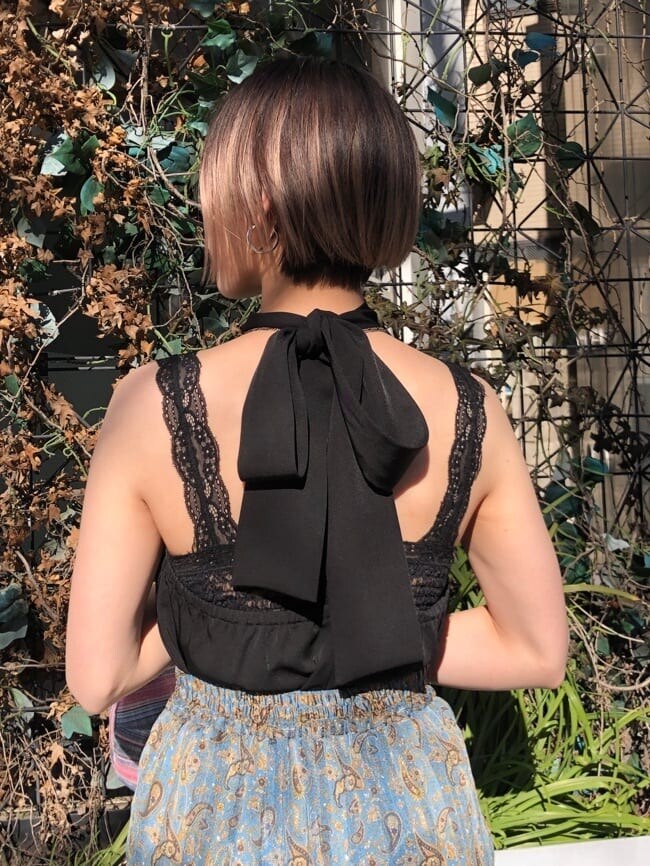 ブルー系のベスト、ブラック系のキャミソール、ホワイト系のボストンバッグを着用したレディースの夏コーディネートの7枚目の写真