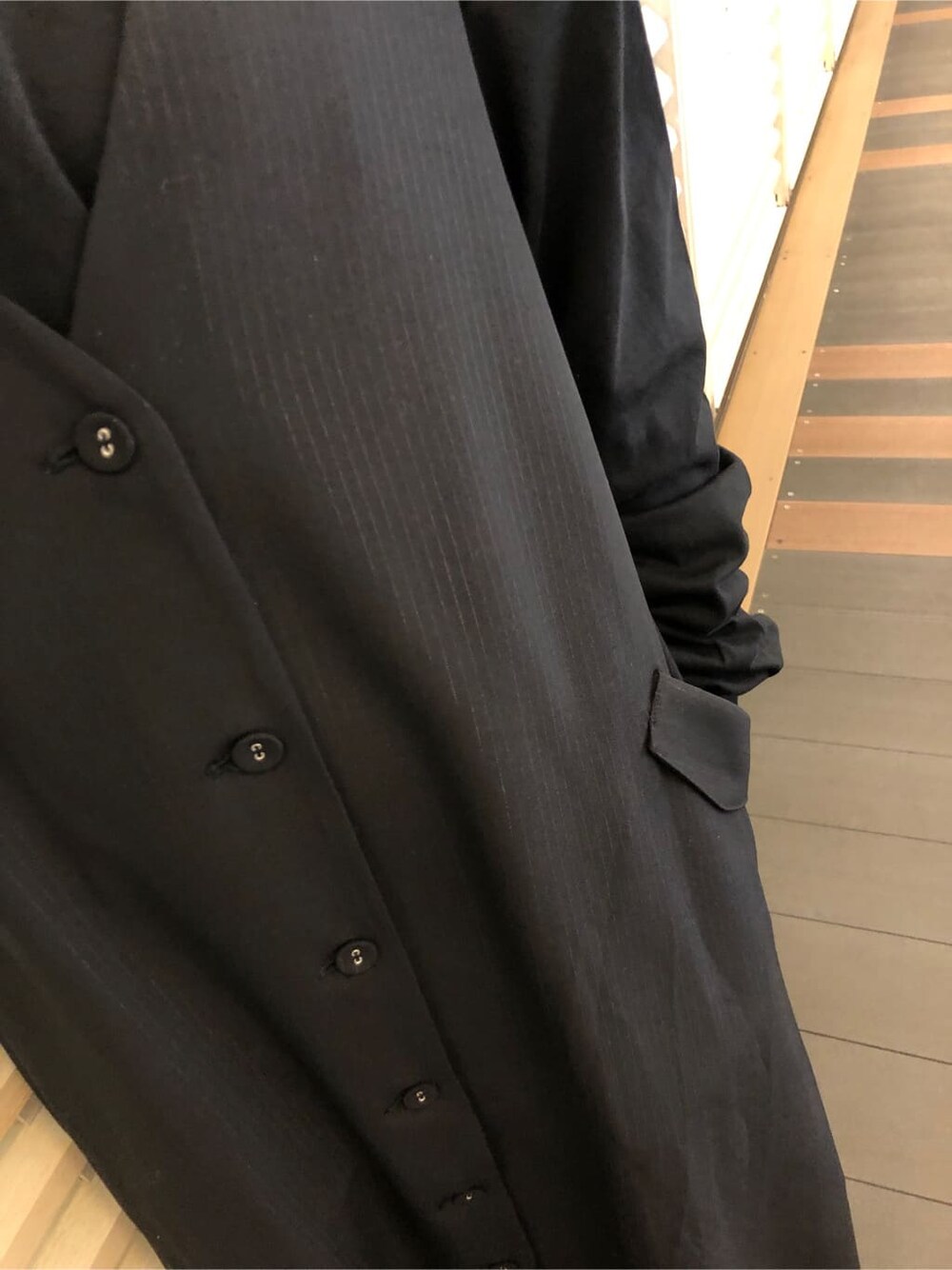 ホワイト系のシャツ/ブラウス、ブラック系のジャンパースカート、ホワイト系のブーツを着用したレディースの春コーディネートの6枚目の写真