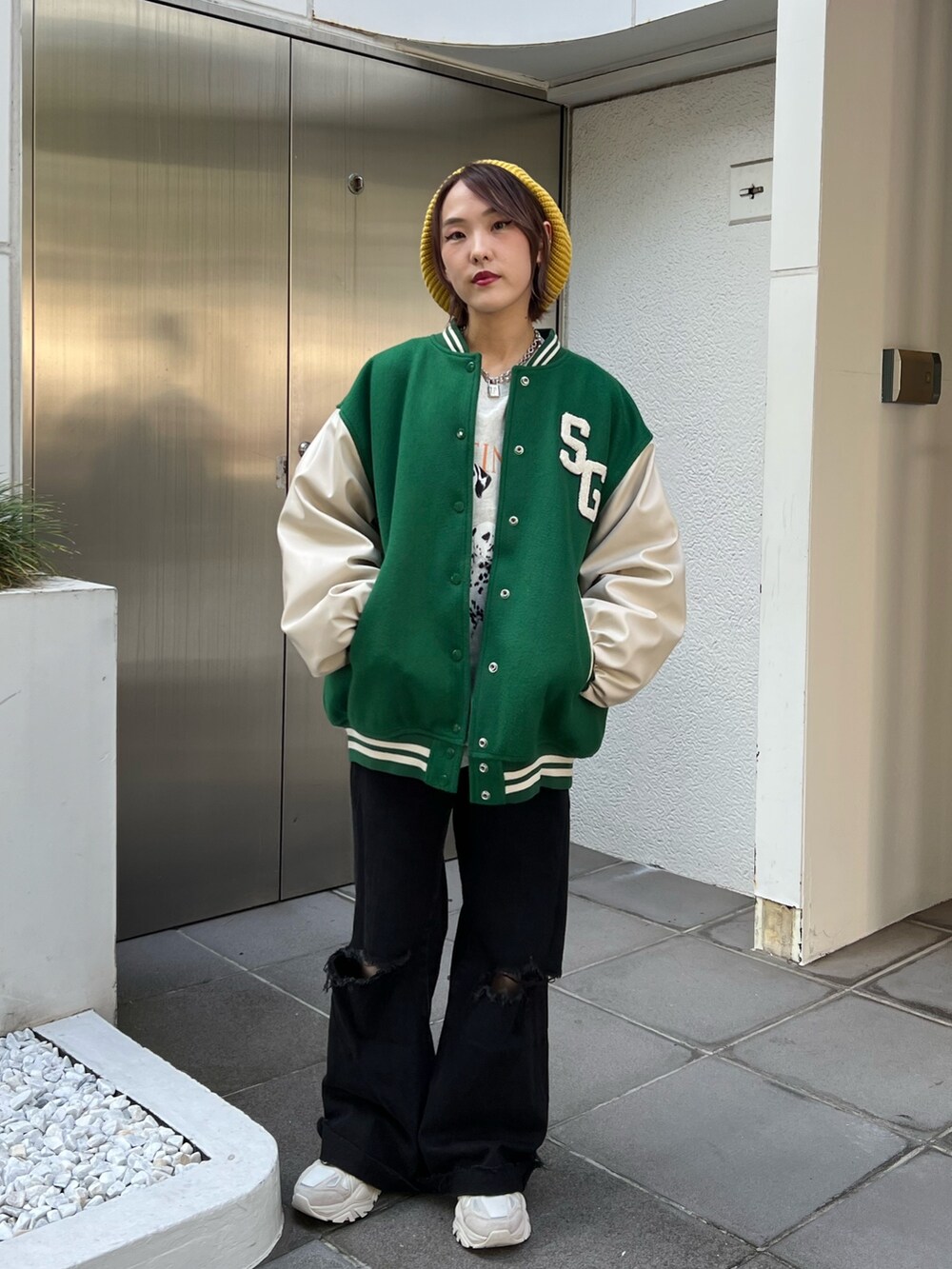 グレー系のスウェット、グリーン系のスタジャン、ホワイト系のスニーカーを着用したレディースの秋コーディネートの5枚目の写真