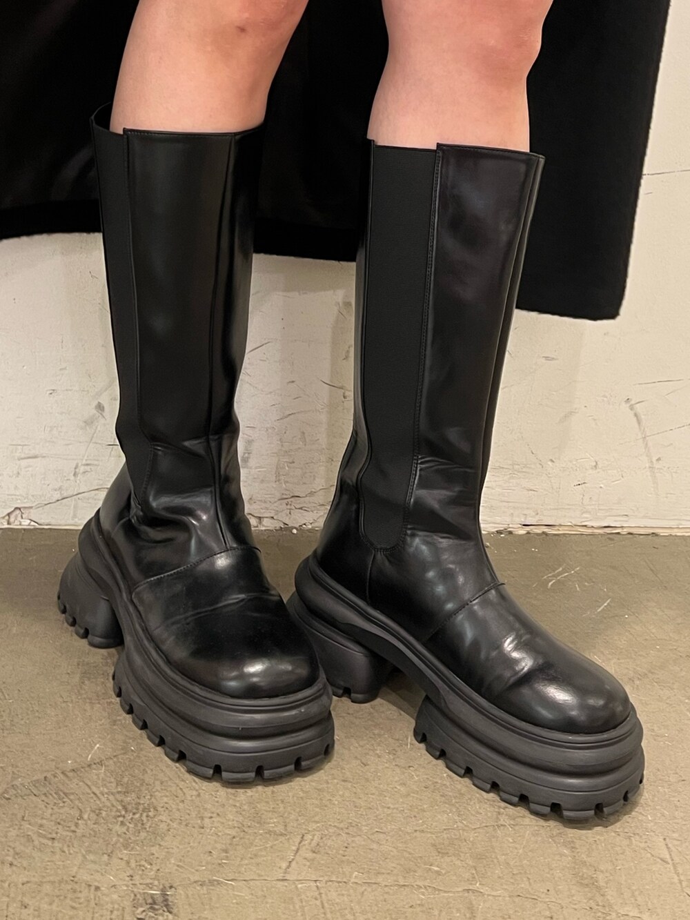 その他のニット/セーター、ブルー系のスカート、ブラック系のチェスターコートを着用したレディースの秋コーディネートの10枚目の写真