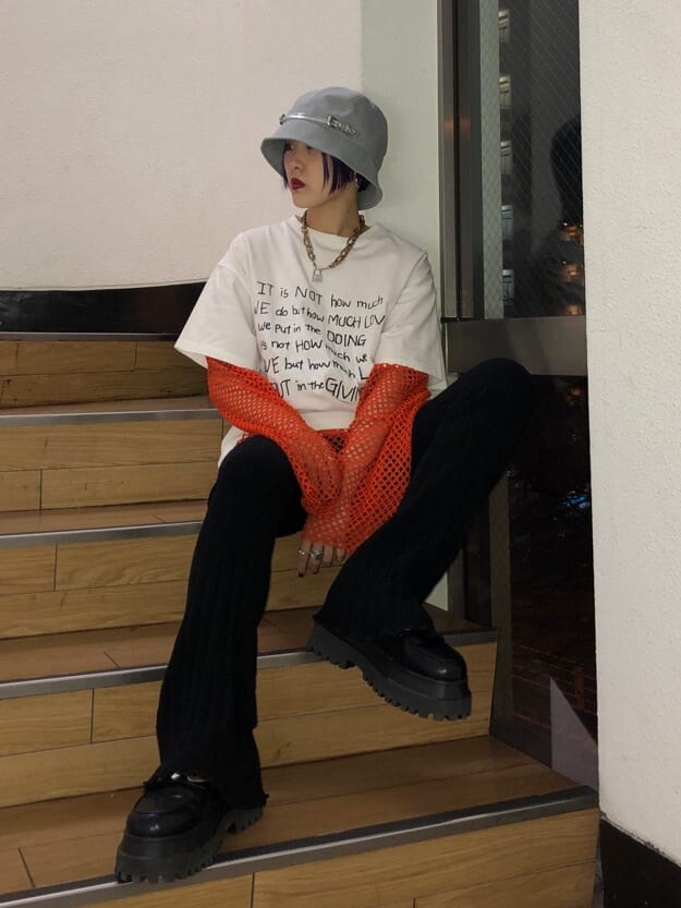 ブラック系のその他パンツ、オレンジ系のTシャツ/カットソー、ホワイト系のTシャツ/カットソーを着用したレディースの冬コーディネートの3枚目の写真