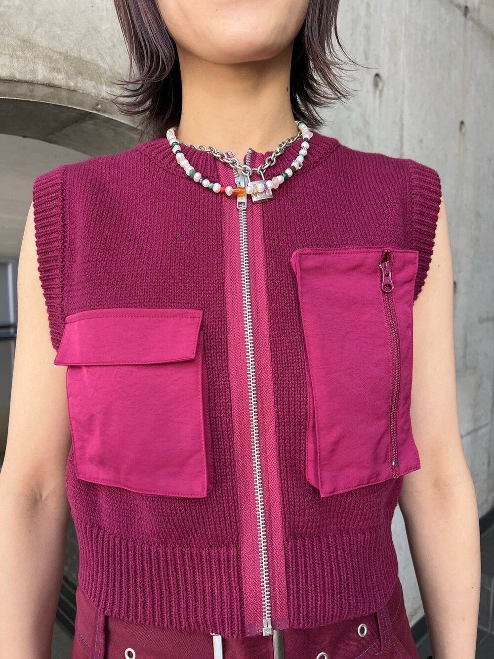 レッド系のその他パンツ、ピンク系のベストを着用したレディースの春コーディネートの5枚目の写真