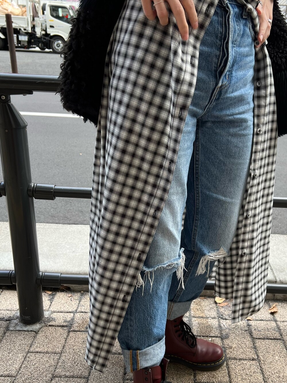 ブラック系のワンピース、ブラック系のベスト、ブルー系のデニムパンツを着用したレディースの冬コーディネートの10枚目の写真