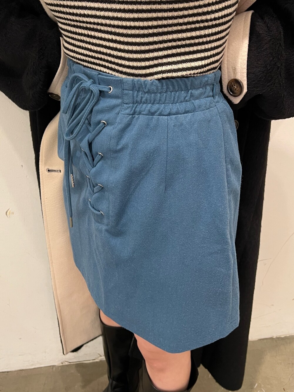 その他のニット/セーター、ブルー系のスカート、ブラック系のチェスターコートを着用したレディースの秋コーディネートの9枚目の写真