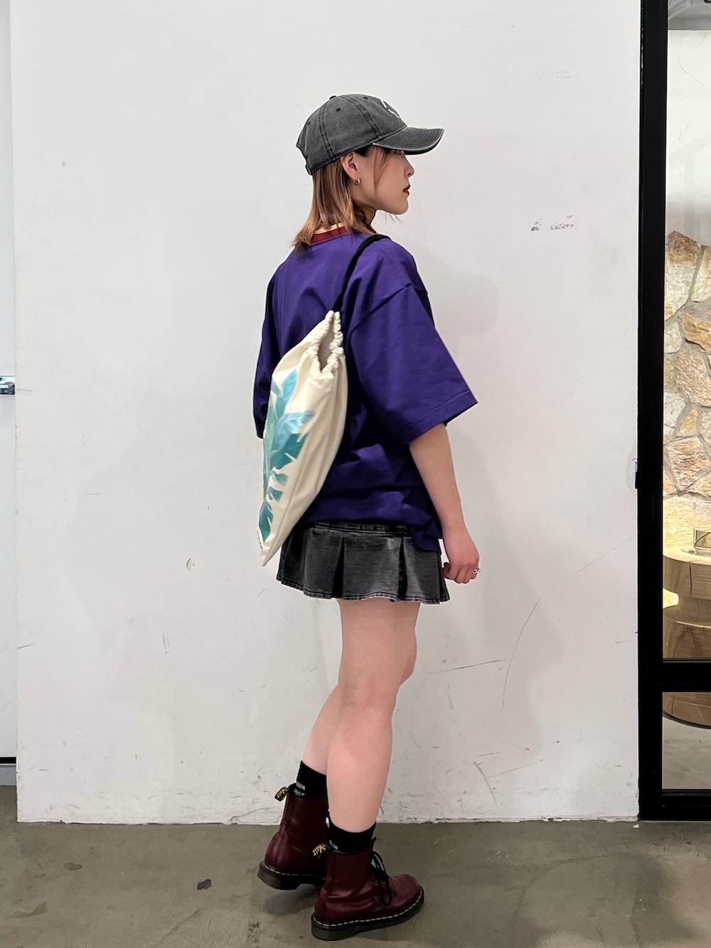 ブラック系のデニムパンツ、パープル系のTシャツ/カットソー、ホワイト系のショルダーバッグを着用したレディースの春コーディネートの4枚目の写真