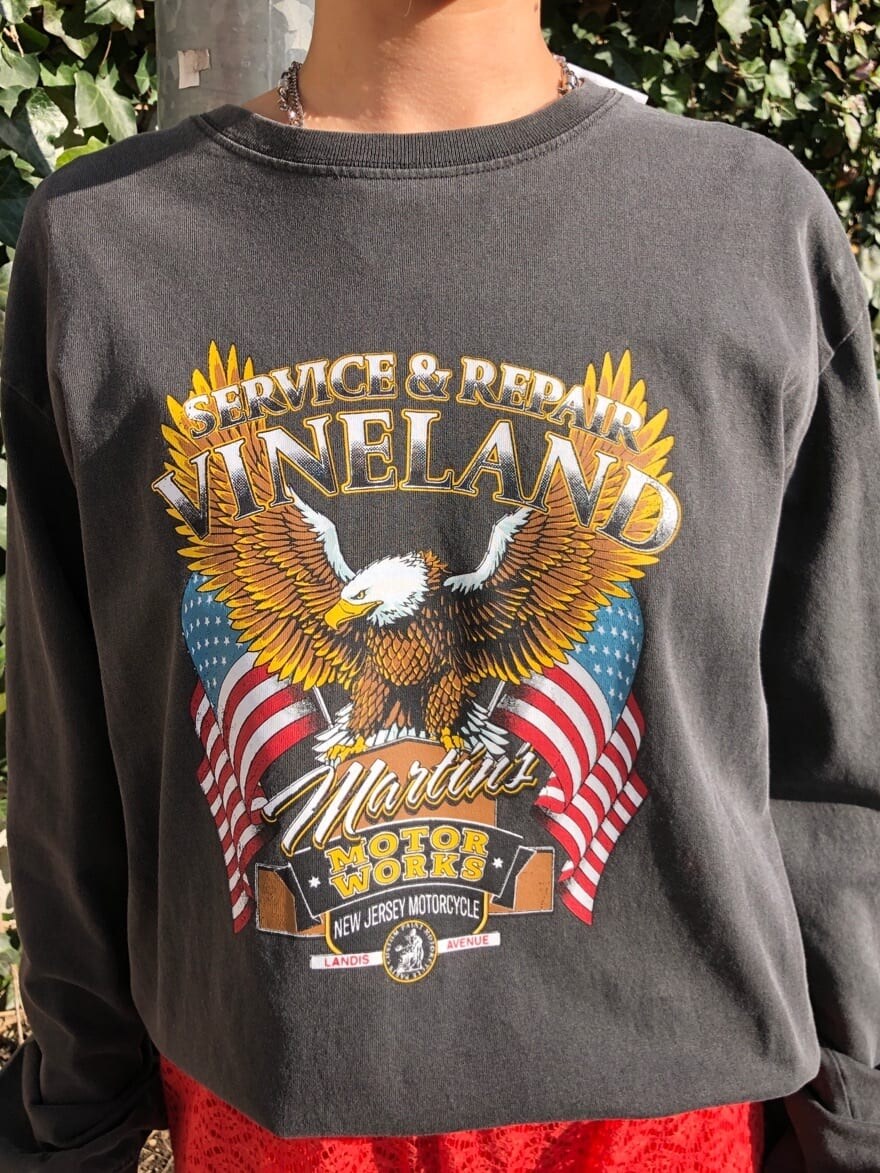 オレンジ系のスラックス、ブラック系のTシャツ/カットソーを着用したレディースの春コーディネートの7枚目の写真