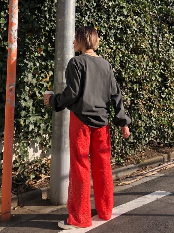 オレンジ系のスラックス、ブラック系のTシャツ/カットソーを着用したレディースの春コーディネートの4枚目の写真