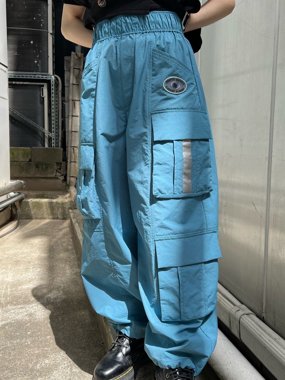 ブラック系のTシャツ/カットソー、ブラック系のテーラードジャケット、ブルー系のカーゴパンツを着用したレディースの夏コーディネートの9枚目の写真