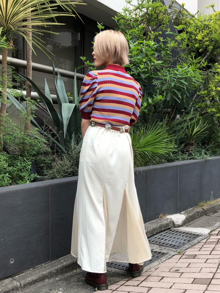 レッド系のニット/セーター、ホワイト系のスカート、ブラック系のショルダーバッグを着用したレディースの夏コーディネートの4枚目の写真