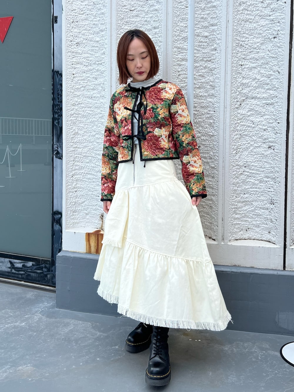 ブルー系のノーカラージャケット、ホワイト系のスカート、シルバー系のTシャツ/カットソーを着用したレディースの春コーディネートの3枚目の写真