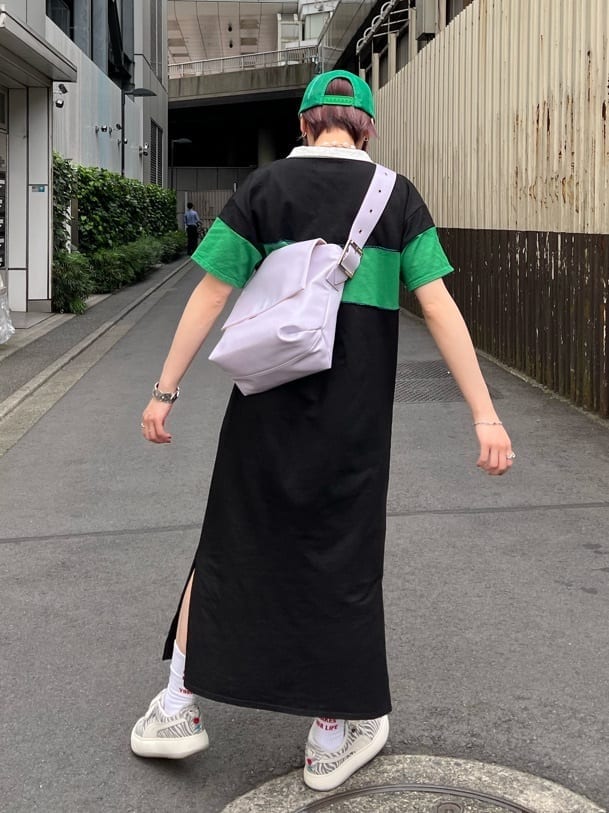 ブラック系のワンピース、パープル系のハンドバッグ、グリーン系のキャップを着用したレディースの夏コーディネートの4枚目の写真