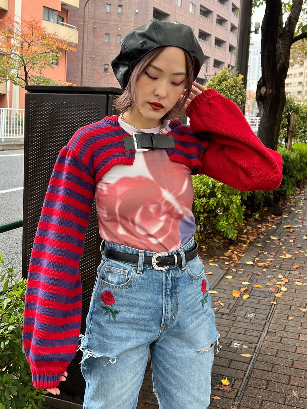 レッド系のニット/セーター、パープル系のTシャツ/カットソー、ブルー系のデニムパンツを着用したレディースの冬コーディネートの5枚目の写真