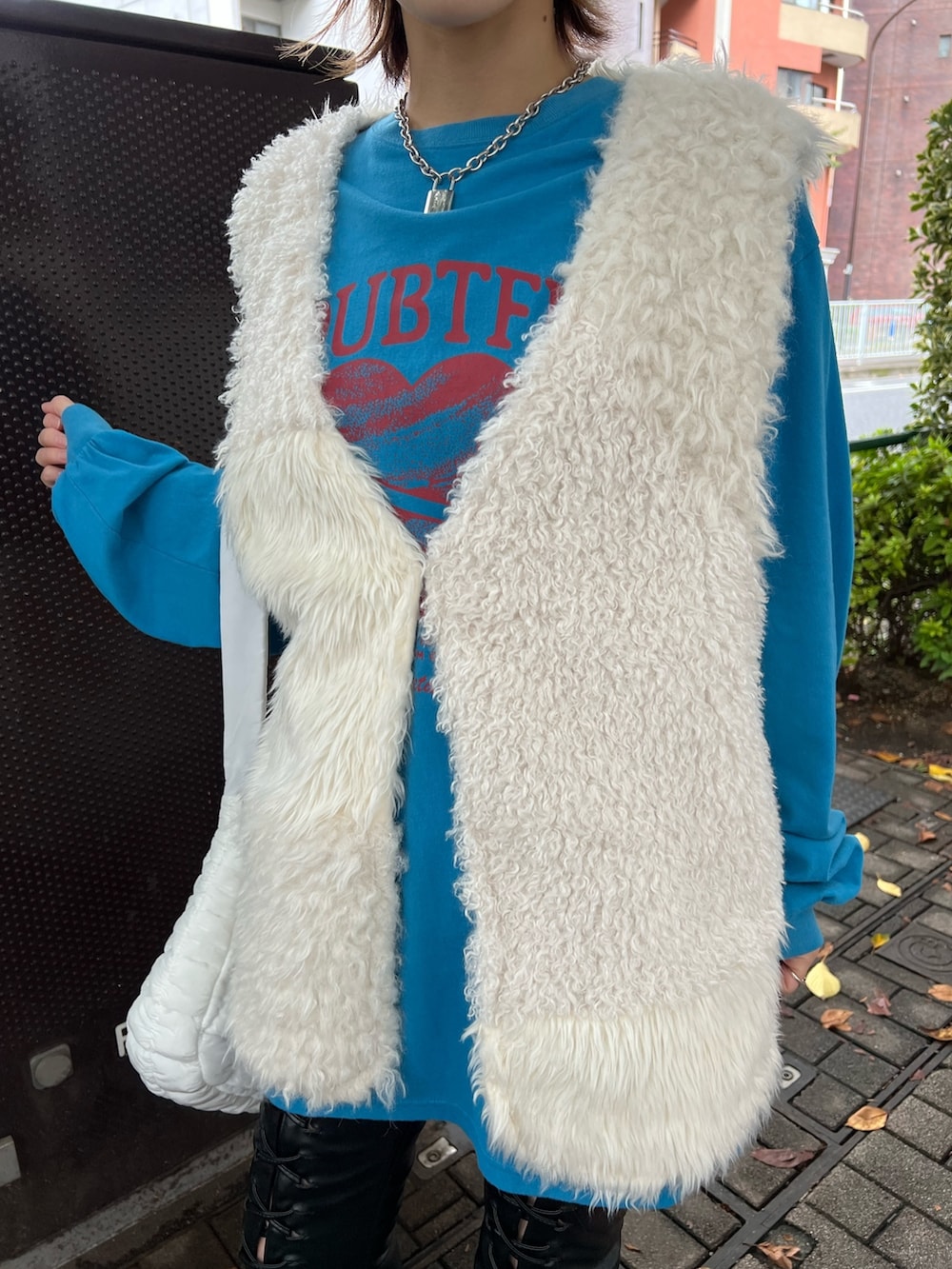 ブルー系のTシャツ/カットソー、ホワイト系のベスト、ホワイト系のハンドバッグを着用したレディースの冬コーディネートの8枚目の写真