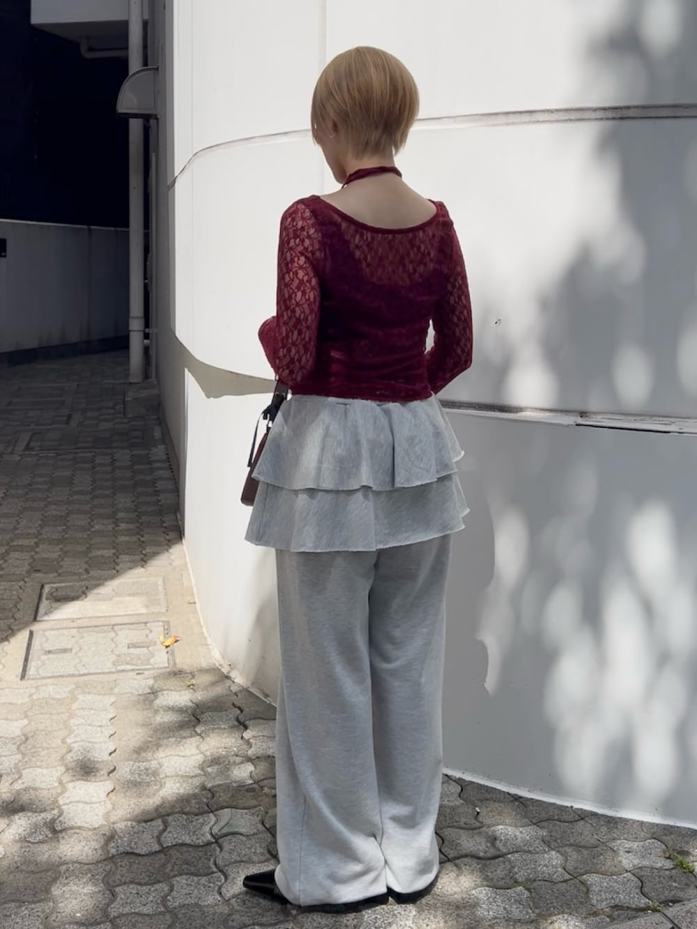 レッド系のTシャツ/カットソー、グレー系のスウェットパンツ、レッド系のハンドバッグを着用したレディースの夏コーディネートの3枚目の写真