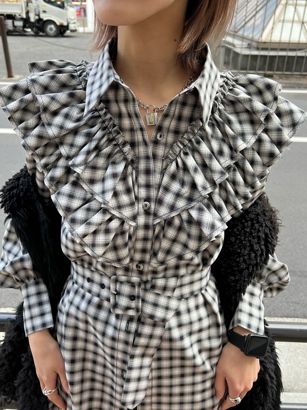 ブラック系のワンピース、ブラック系のベスト、ブルー系のデニムパンツを着用したレディースの冬コーディネートの8枚目の写真